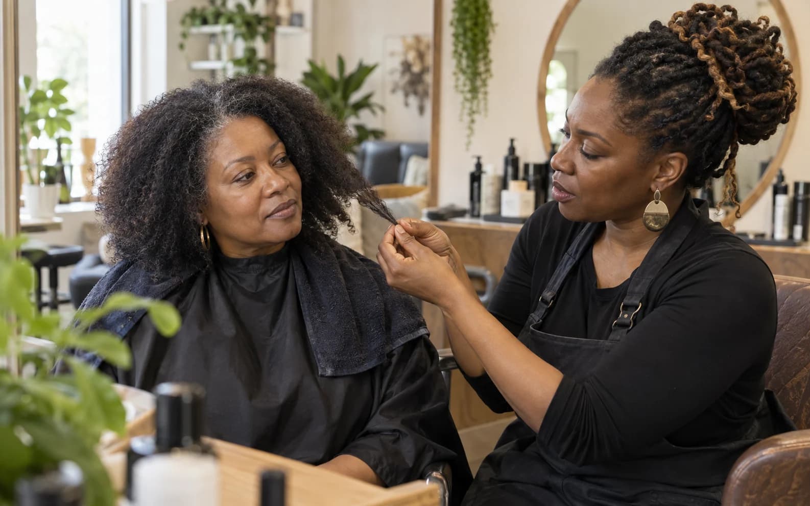 Stylist and client discussing the condition of the client's natural hair