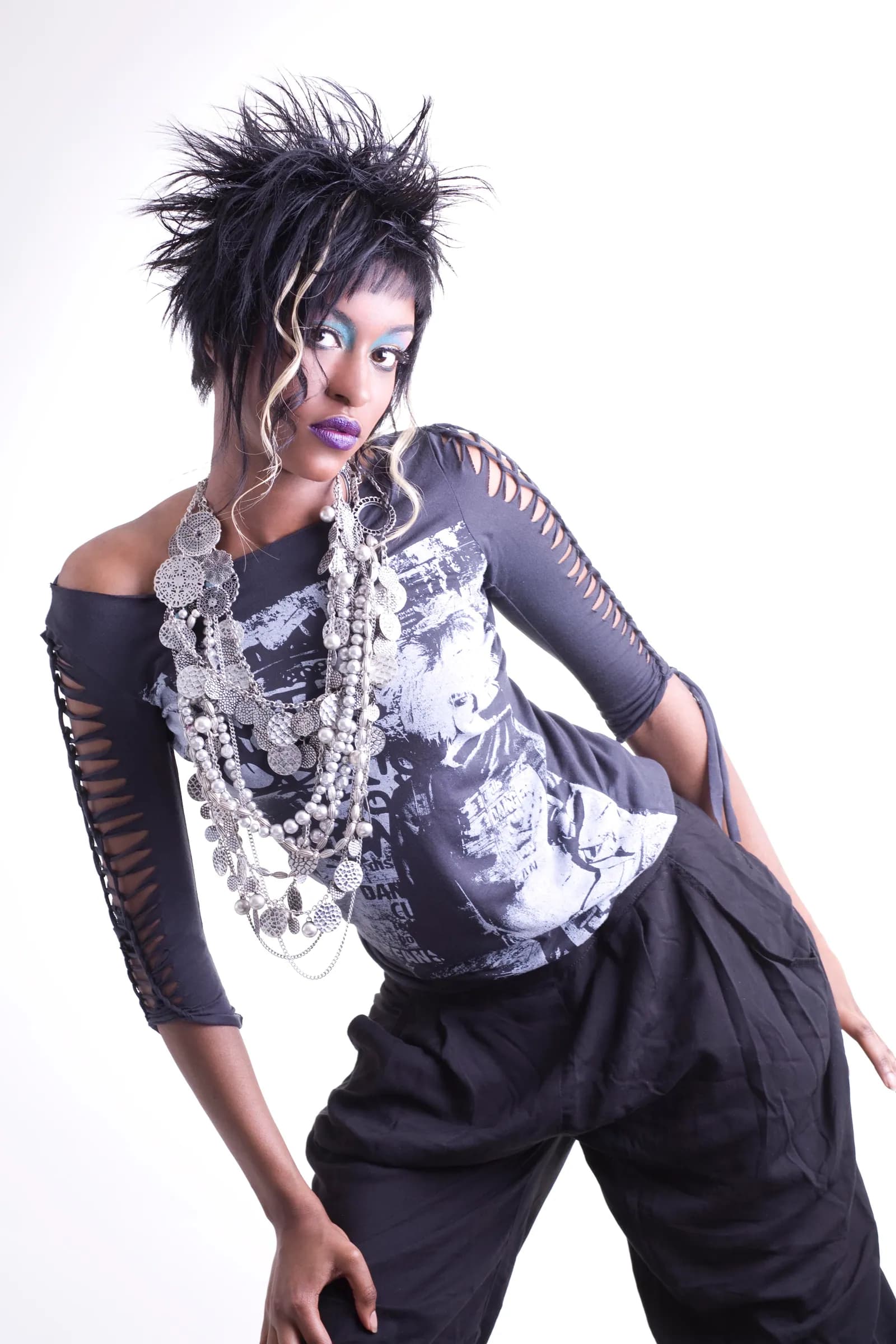 Spiked, textured black hair with layered silver necklaces