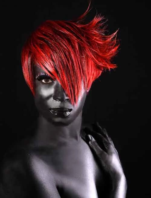 Sweeping red crop falling over one eye, on a model with silver-grey body paint