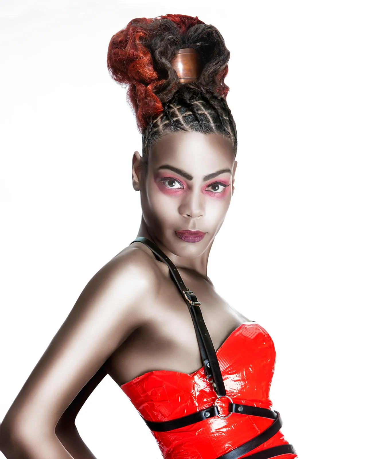 Red curly updo on braided sides, worn with a red and black harness top