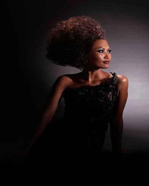 Rounded shape of soft curls, with a black one-shoulder dress