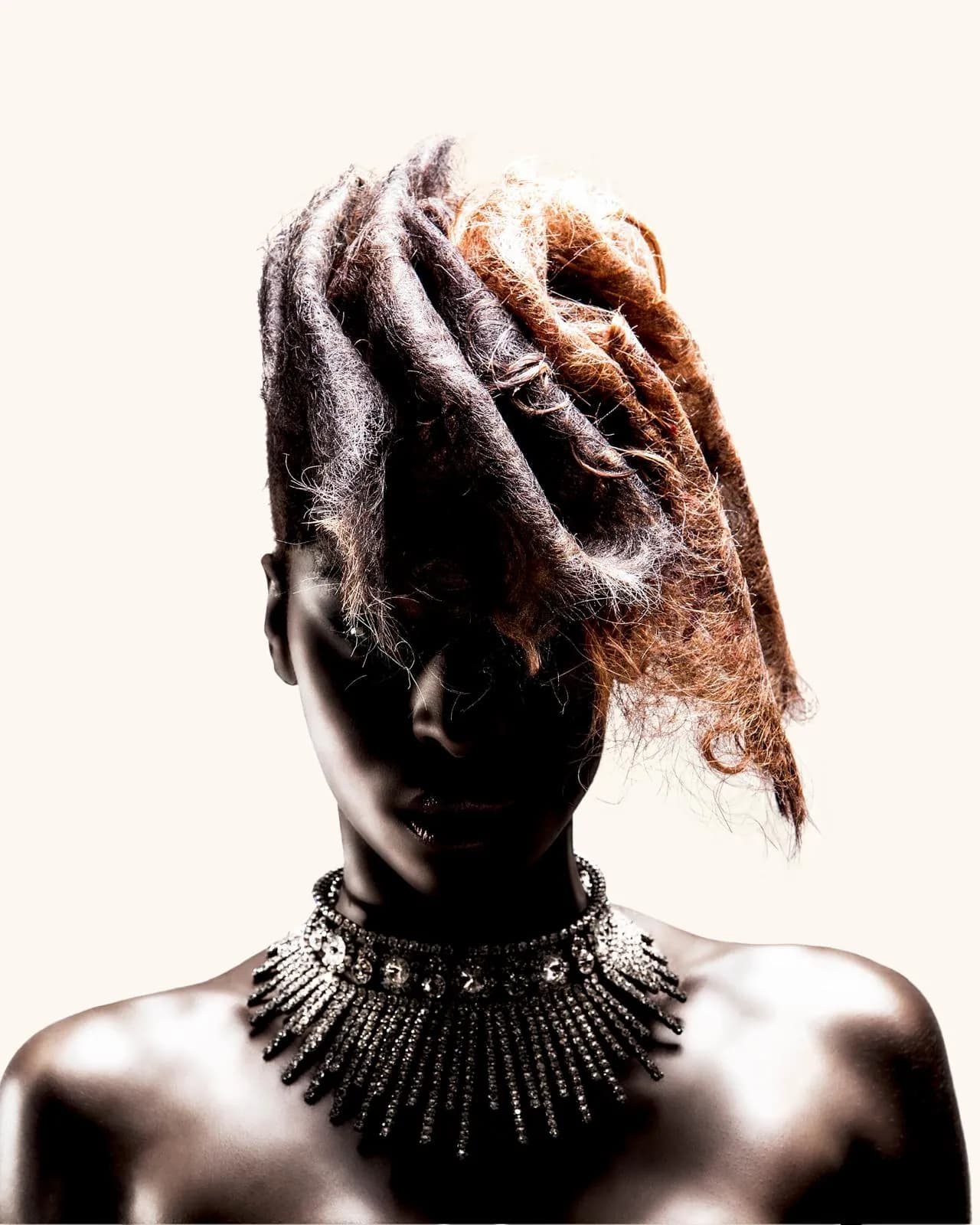 Sculpted twists tipped with copper falling over the face, with a studded collar